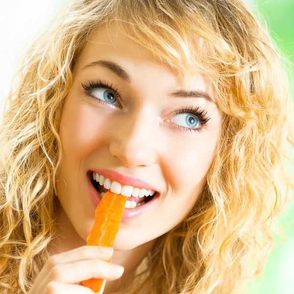 Young woman eating carrots — Stock Photo, Image