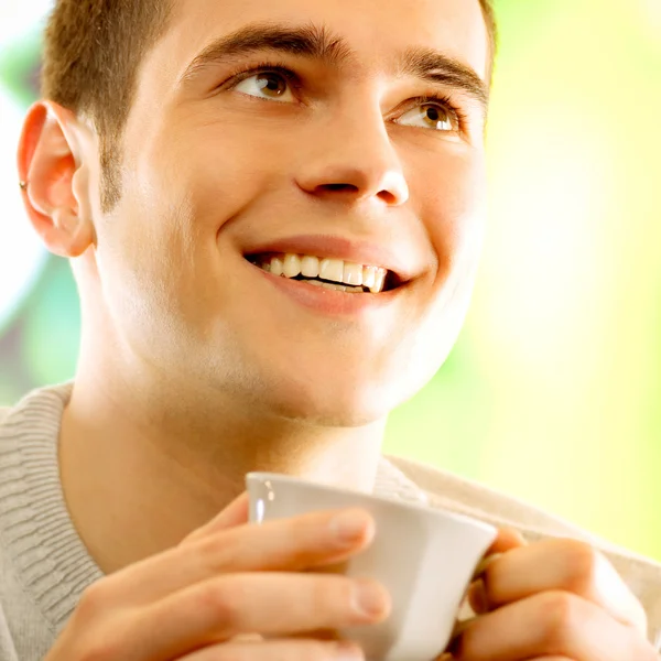 Joven hombre sonriente feliz con taza de café — Foto de Stock