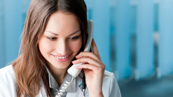 Jeune médecin au téléphone, au bureau — Photo