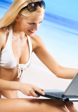 laptop sahilde bir kadınla