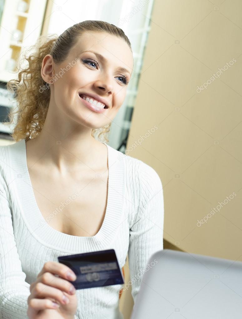 Cheerful woman paying by plastic card