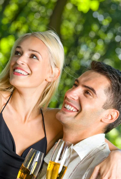 Jeune couple heureux avec champagne, en plein air — Photo