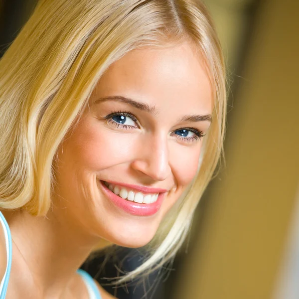 Glimlachend jonge mooie vrouw, binnenshuis — Stockfoto