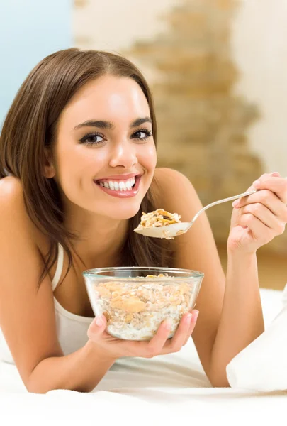 Jovem mulher comendo musselina de cereais (flocos ) — Fotografia de Stock