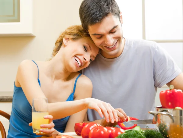 Alegre joven cocina pareja en casa — Foto de Stock