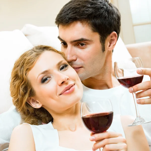 Casal alegre com copos de vinho tinto — Fotografia de Stock