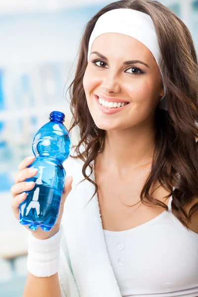 Vrouw met fles water, op fitnessclub — Stockfoto
