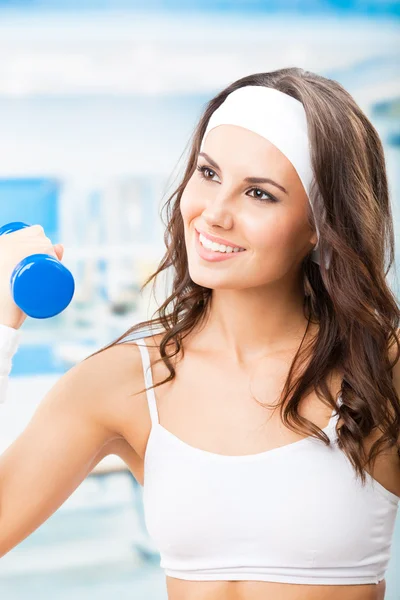 Mujer haciendo ejercicio con la mancuerna, en el gimnasio — Foto de Stock