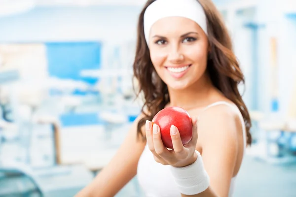 Woman with apple, at fitness center — Stock Photo, Image
