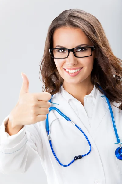 Doctora con el dedo pulgar hacia arriba, sobre gris —  Fotos de Stock