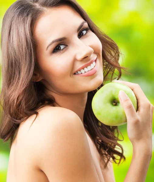 Jonge gelukkig lachende vrouw met apple, buitenshuis — Stockfoto