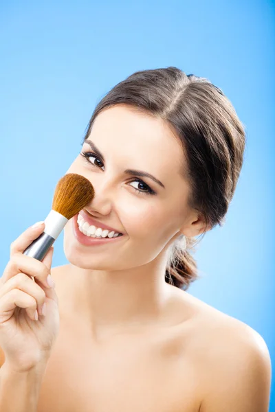 Kvinna med kosmetika pensel, på blå — Stockfoto
