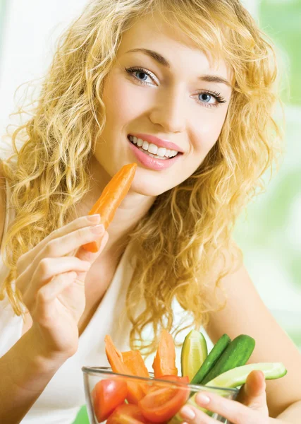 Jeune femme mangeant des légumes — Photo