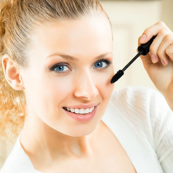 Cheerful woman applying mascara with lash brush — Stock Photo, Image