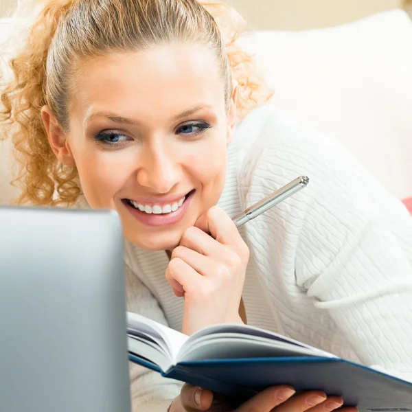 Vrolijke vrouw die werkt met de organisator en laptop — Stockfoto