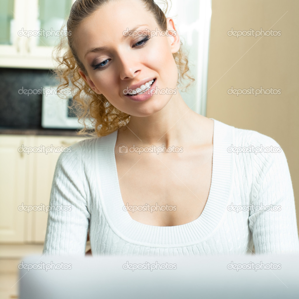 Cheerful woman with laptop, at home
