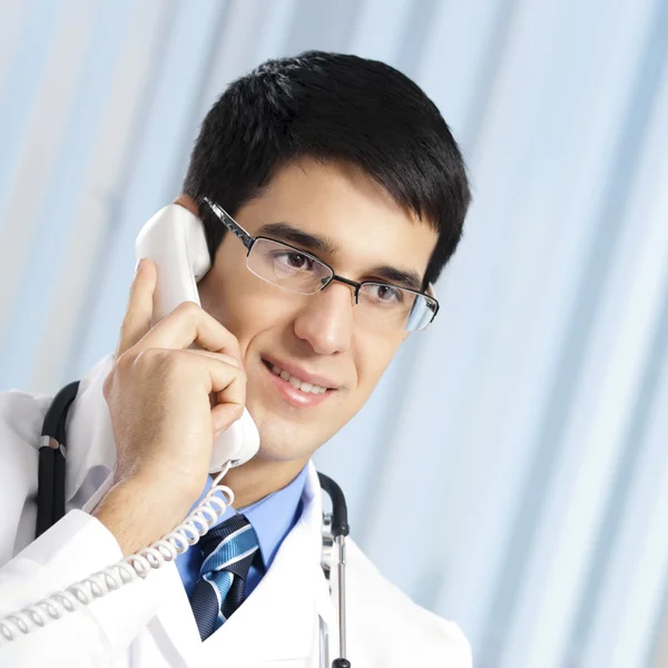 Jeune médecin au téléphone, au bureau — Photo