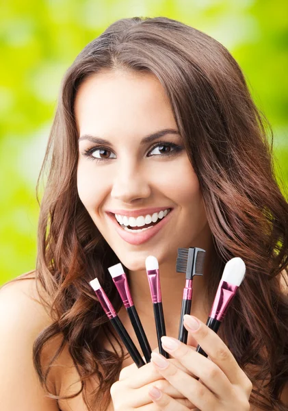 Lachende vrouw met make-up tools, buiten — Stockfoto