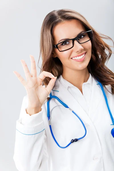 Medico donna con gesto positivo, sopra grigio — Foto Stock