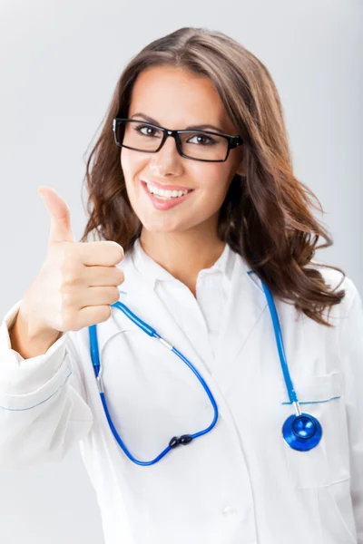 Medico femminile con i pollici in su gesto, sopra grigio — Foto Stock