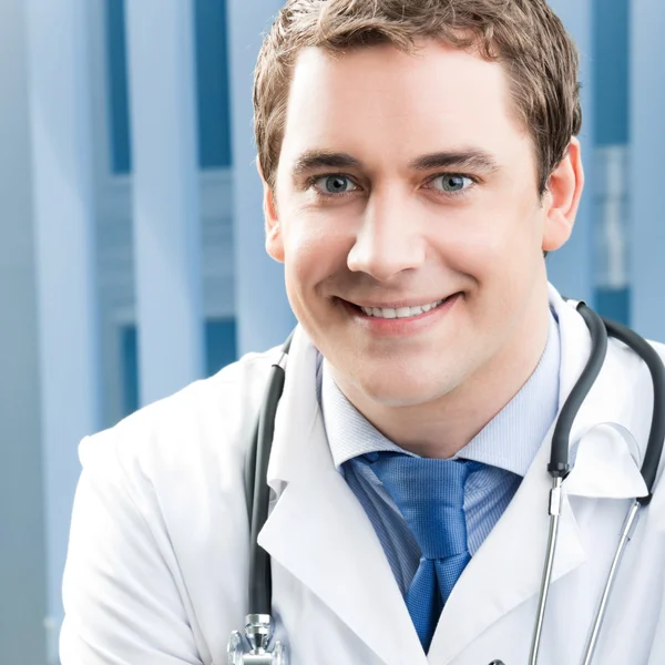 Feliz sonriente joven médico en el consultorio —  Fotos de Stock