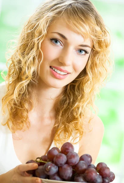 Jeune femme heureuse avec assiette de raisin — Photo
