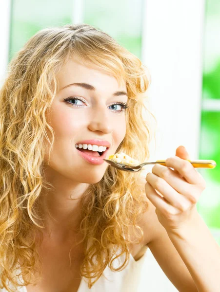 Mulher alegre comendo musselina de cereais — Fotografia de Stock