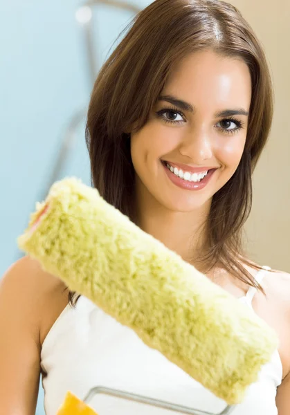 Woman with paint roller in new house — Stock Photo, Image
