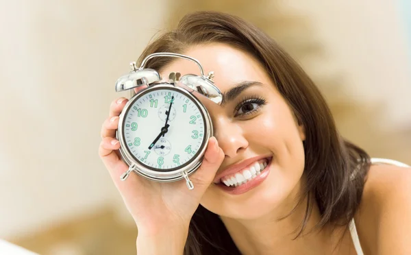 Woman with alarmclock on the bed — Stock Photo, Image