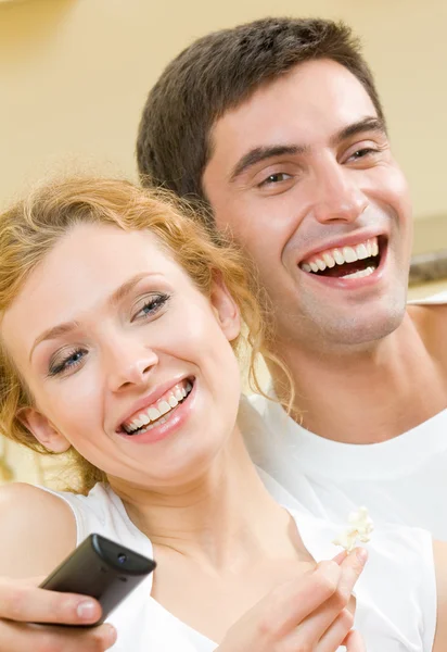 Glada unga par tittar på tv tillsammans — Stockfoto
