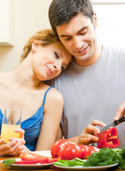 Cheerful young cooking couple at home — Stockfoto