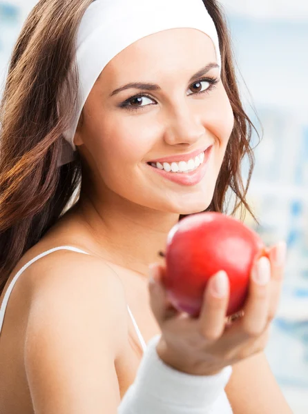 Woman with apple, at fitness center — Stock Photo, Image