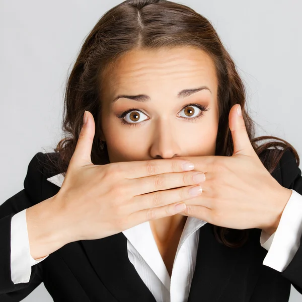 Business woman covering mouth, over gray — Stock Photo, Image