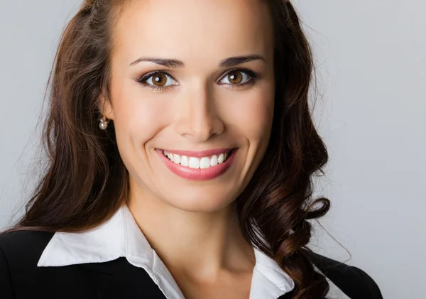Щаслива усміхнена молода бізнес-леді, на сірому — стокове фото
