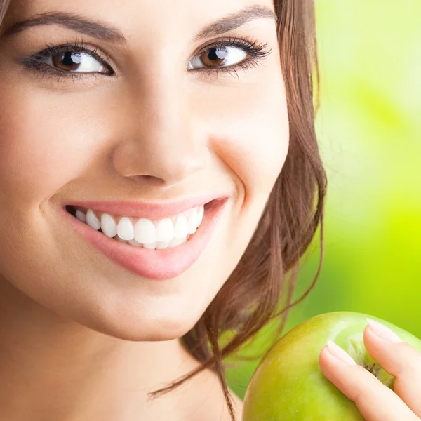 Junge glücklich lächelnde Frau mit Apfel, im Freien — Stockfoto