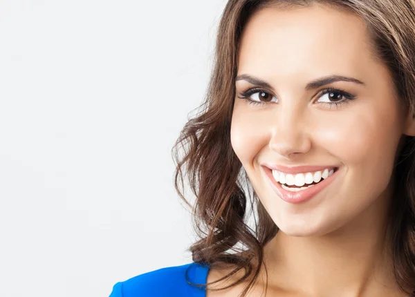 Happy smiling young woman, over grey — Stock Photo, Image