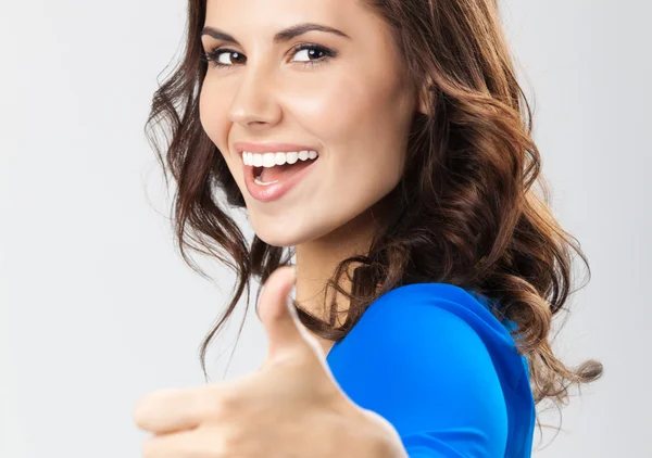 Young woman with thumbs up gesture, over grey — Stock Photo, Image