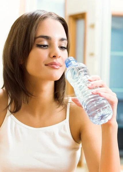 Молода жінка п'є воду, в приміщенні — стокове фото