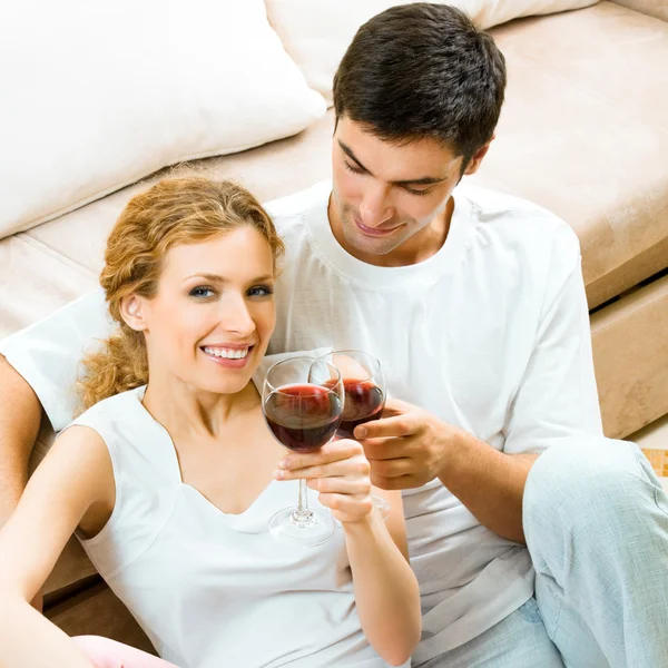 Casal alegre com copos de vinho tinto — Fotografia de Stock