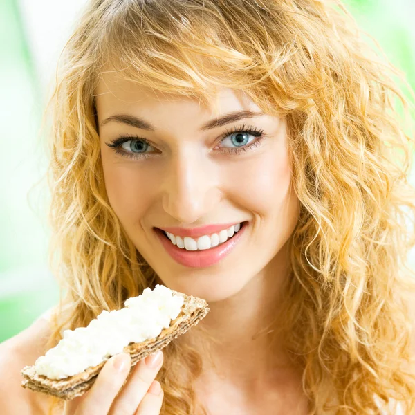 Portrait of young happy woman eating crispbread Stock Image