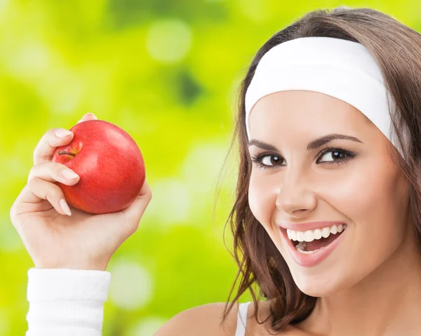 Mujer en ropa de fitness con manzana, al aire libre —  Fotos de Stock