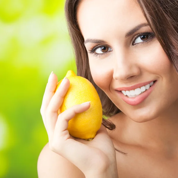 Jonge gelukkig lachende vrouw met citroen, buitenshuis — Stockfoto