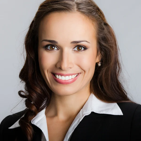 Feliz joven empresaria sonriente, en gris — Foto de Stock