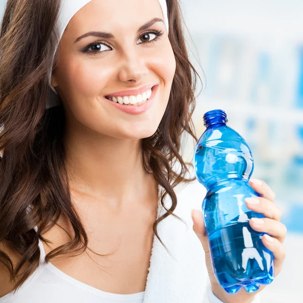 Frau mit Flasche Wasser, im Fitnessclub — Stockfoto