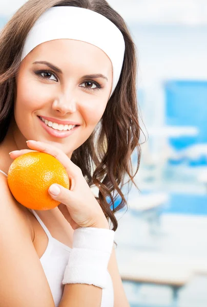 Mujer con naranja, en el gimnasio — Foto de Stock