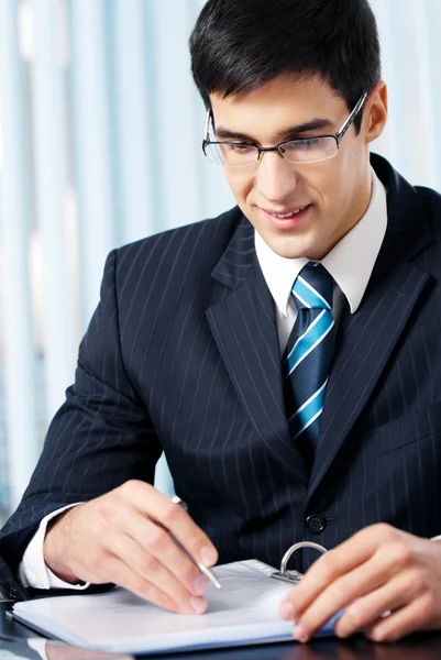 Portrait of writing smiling businessman working at office — Stock Photo, Image