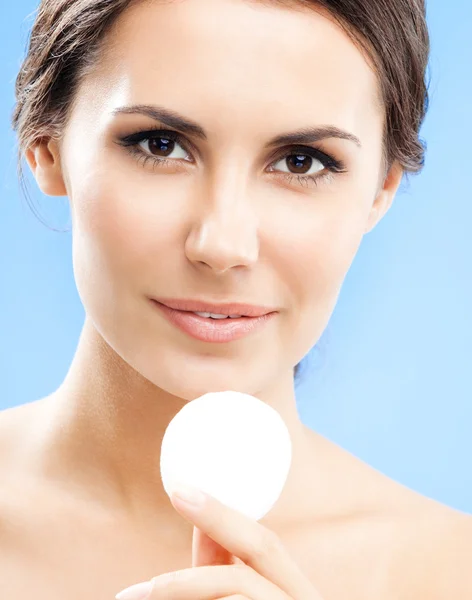 Young woman cleaning skin by cotton pad, over blue — Stock Photo, Image