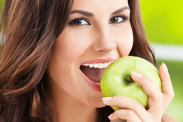 Young woman eating apple, outdoors — Stock Photo, Image