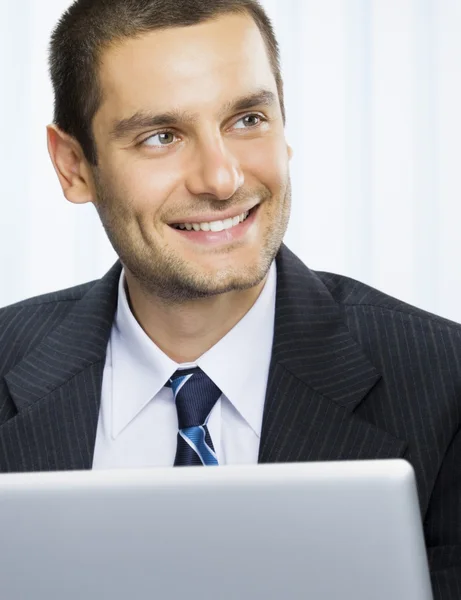 Empresário sorridente trabalhando com laptop no escritório — Fotografia de Stock