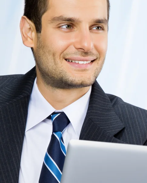 Homme d'affaires souriant travaillant avec un ordinateur portable — Photo
